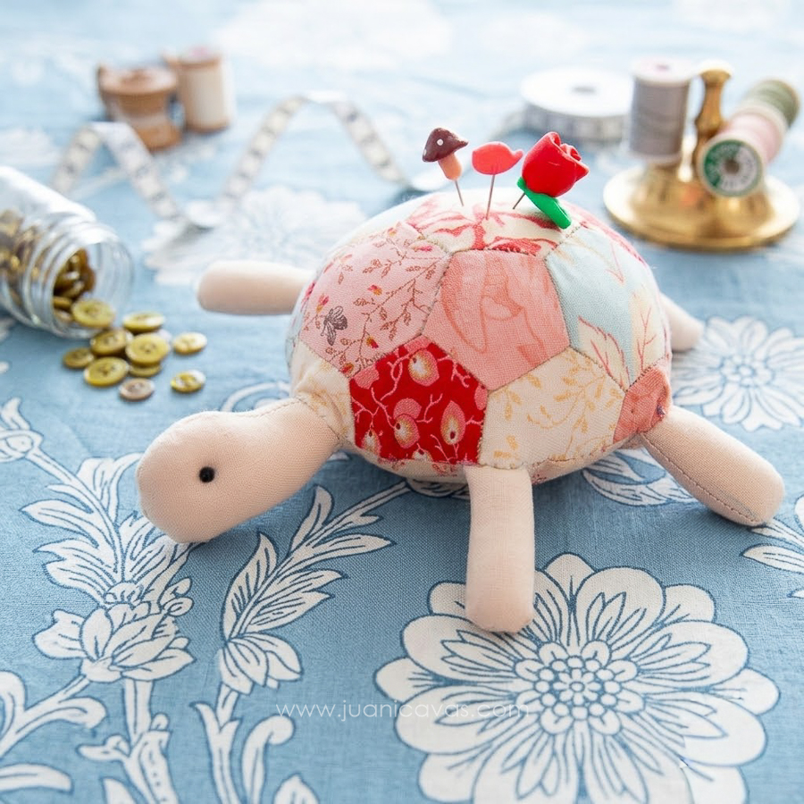 Tortuga alfiletero de patchwork inglés sobre tela azul con hilos y botones